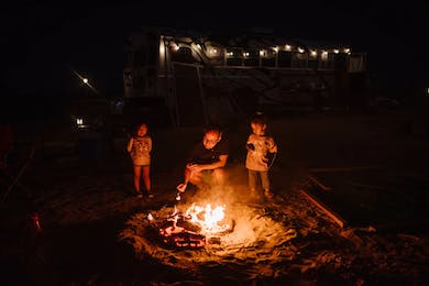 Kids Roasting Smores at a campfire with a grown-up. Desert Bonfire Family Friendly Events in Los Angeles